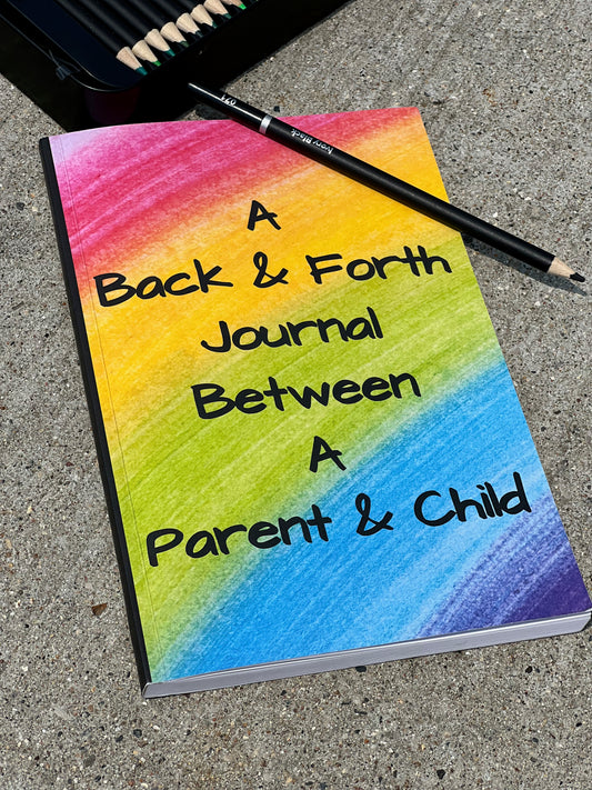 Journal titled 'A Back & Forth Journal Between A Parent & Child' with a colorful cover on a concrete surface.